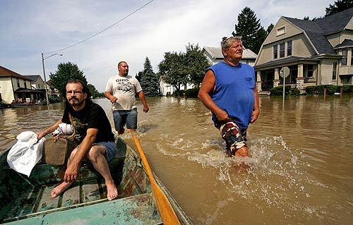 In the worst flooding in nearly a century, the town of Findlay, Ohio, received more than seven inches of rain in a month. Hundreds of residents have been forced from their homes, including Johnny Blaze, left, who was rescued via watercraft Wednesday with the help of Robert Evan, middle, and Dene Lynn. Ohio Gov. Ted Strickland declared a state of emergency in nine counties in northern Ohio where roads are impassable, schools have been closed and storm shelters opened.