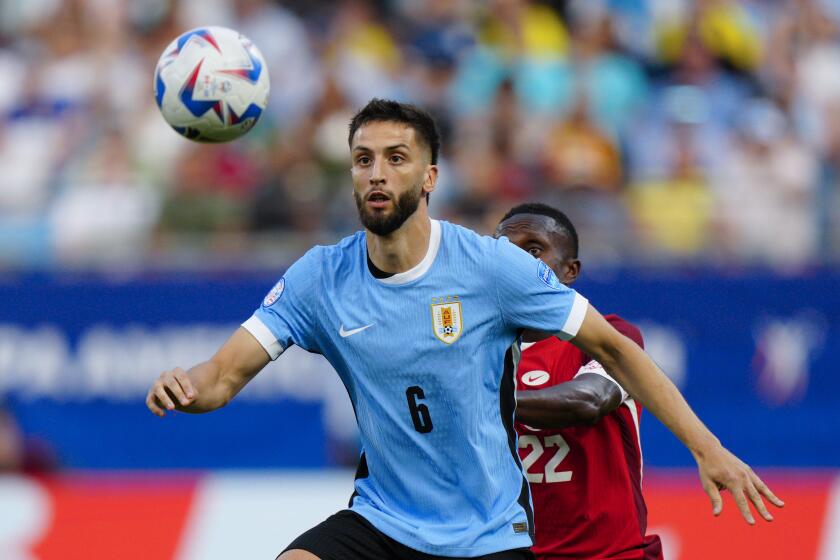 ARCHIVO - El volante uruguayo Rodrigo Bentancur pugna por el balón con el canadiense Richie Laryea en el partido por el tercer puesto de la Copa América, el 13 de julio de 2024, en Charlotte. (AP Foto/Jacob Kupferman)