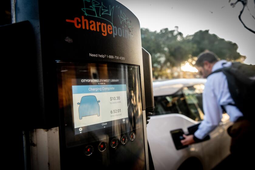 BERKELEY, CA - DECEMBER 01, 2021 - A man disconnects his vehicle from an electric vehicle charging station at the Berkeley Public Library West Branch in Berkeley, California on December 01, 2021. (Josh Edelson/for the Times)
