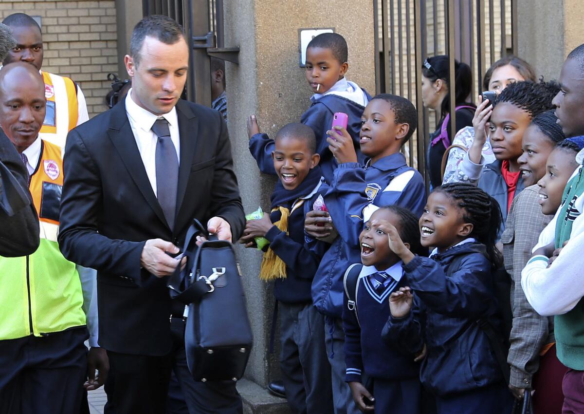 Children react as Oscar Pistorius, left, leaves the high court in Pretoria, South Africa, on Monday.