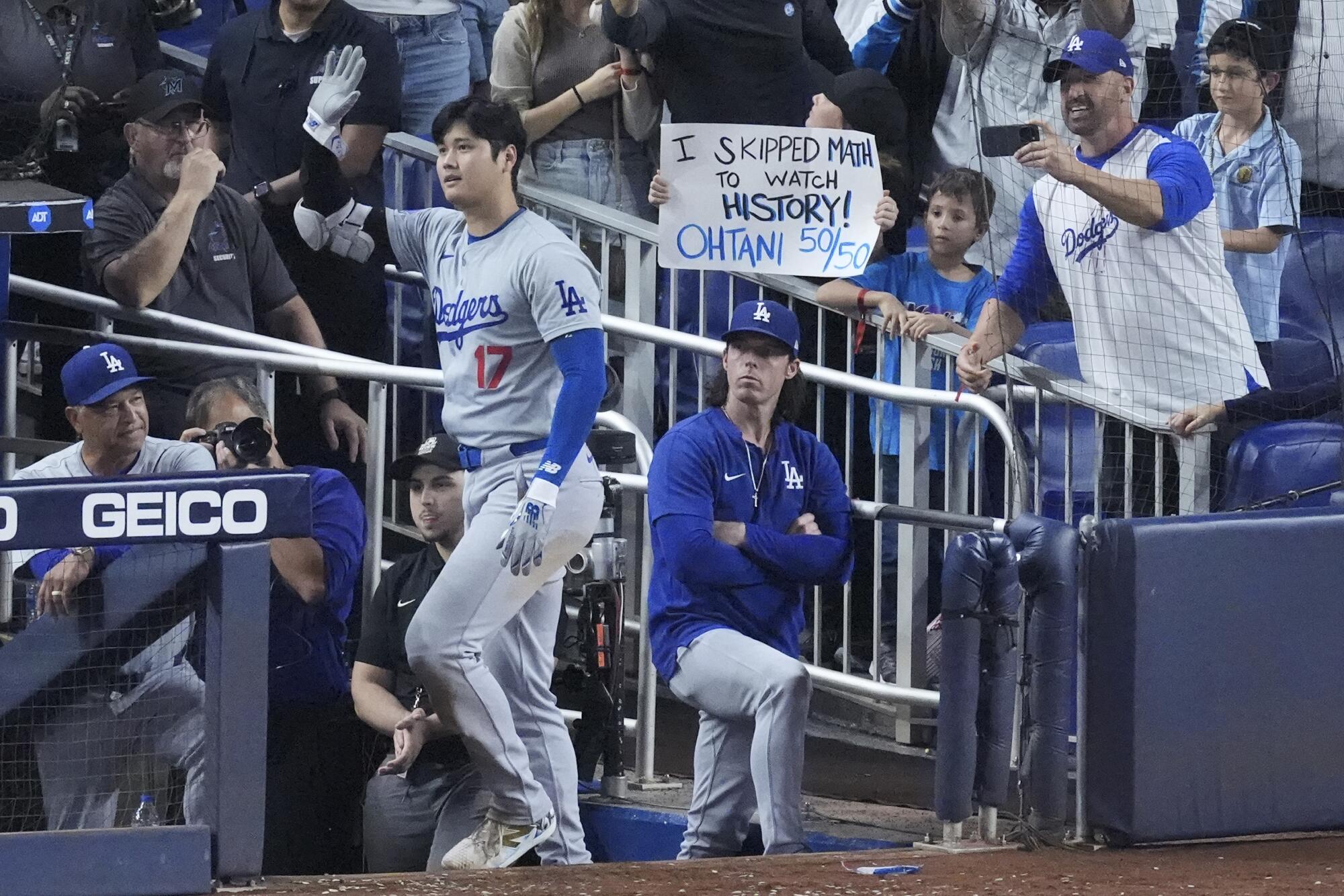 Shohei Ohtani waves to the crowd after stepping out of the dugout to take a curtain call after hitting his 50th home run.