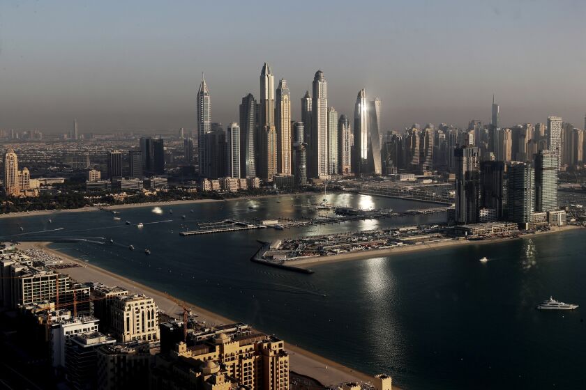 FILE - Luxury towers that dominate the skyline in the Dubai Marina district, center, and the new Dubai Harbor development, right, are seen from the observation deck of "The View at The Palm Jumeirah" in Dubai, United Arab Emirates, on April 6, 2021. A senior United Arab Emirates official says the Gulf nation wants a U.N. climate summit it’s hosting later this year to deliver “game-changing results” for international efforts to curb global warming. But UAE diplomat Majid al-Suwaidi said doing so will require having the fossil fuel industry at the table. (AP Photo/Kamran Jebreili, File)