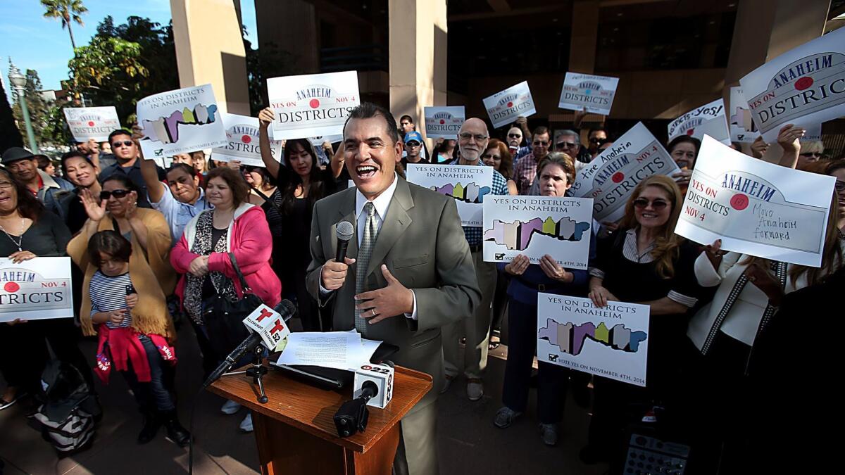 Jose Moreno is joined by members of the community at a news conference in 2014 to announce an agreement with the Anaheim mayor and City Council to put the issue of district elections on the ballot later that year. Moreno was elected to the council last November.