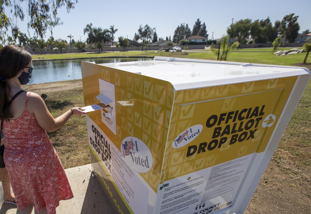 A voter places her ballot in a drop box in Orange County on Oct. 13, 2020. 