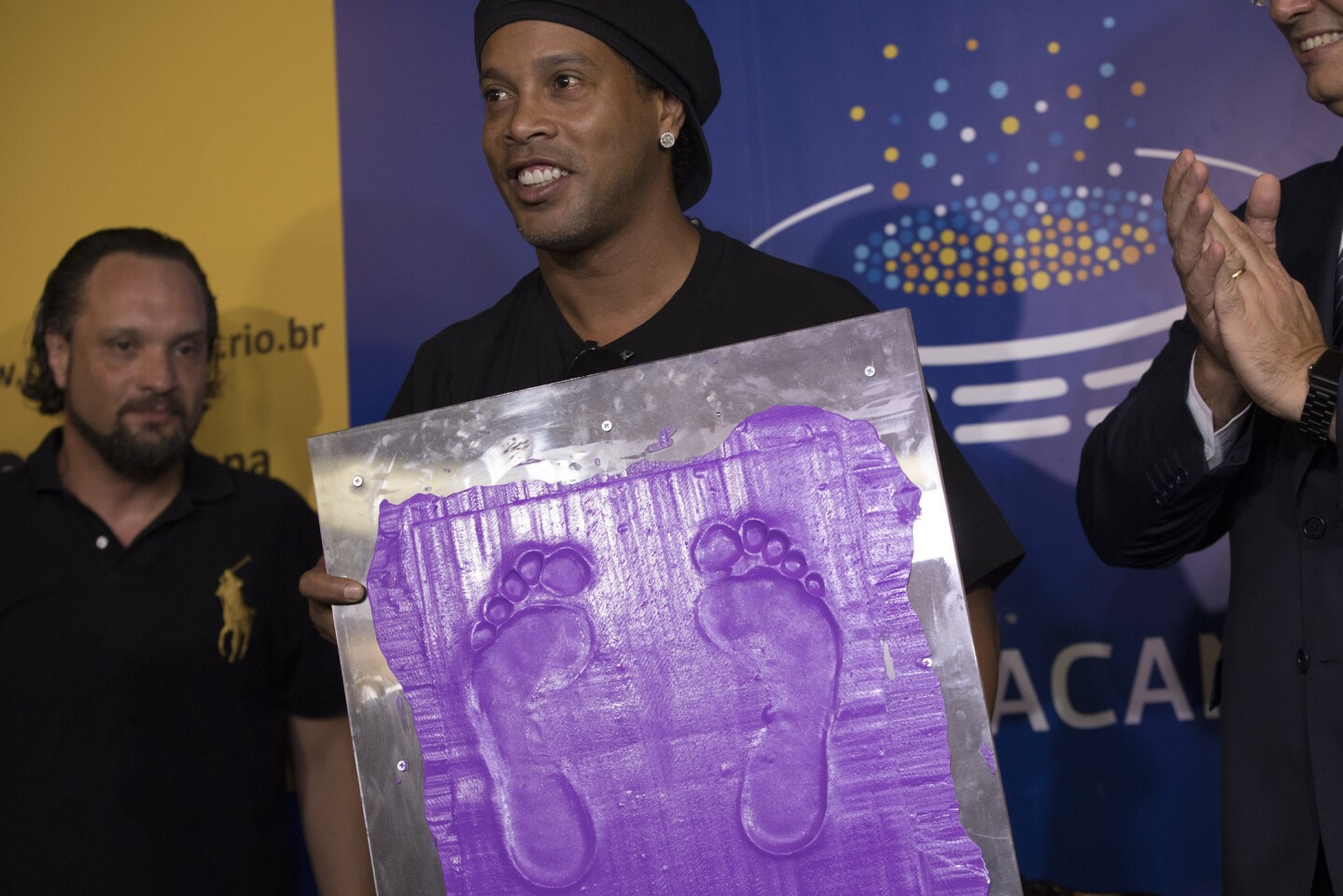Brazil's former soccer player Ronaldinho Gaucho holds a print of his feet that will be placed on Brazil's Soccer Walk of Fame at Maracana stadium in Rio de Janeiro, Brazil, Tuesday, Jan. 8, 2019. Ronaldinho was twice named FIFA World Player of the Year. (AP Photo/Leo Correa)