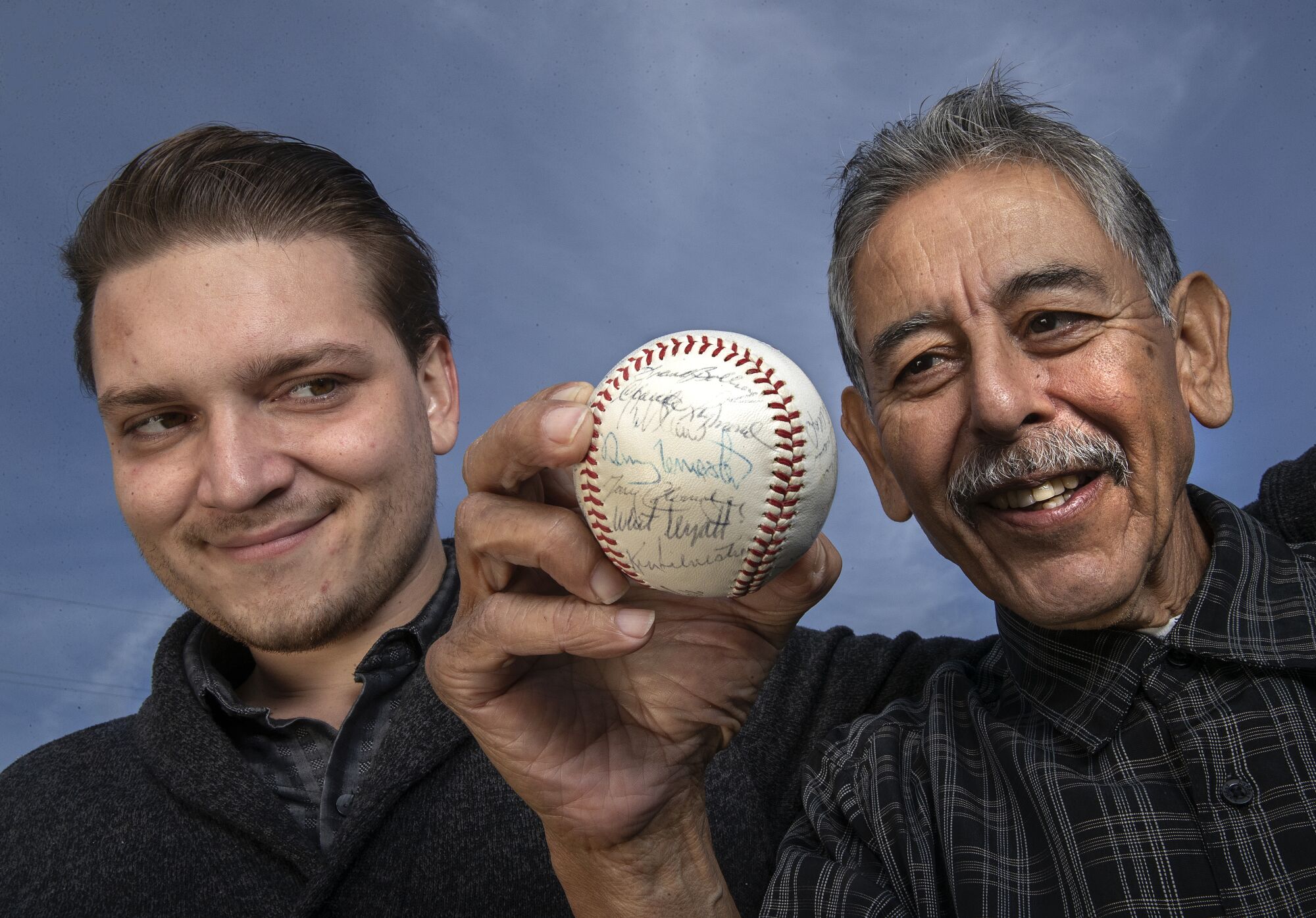 Alec Salinas and his grandfather Buddy Salinas, with a baseball signed by the 1963 Milwaukee Braves.