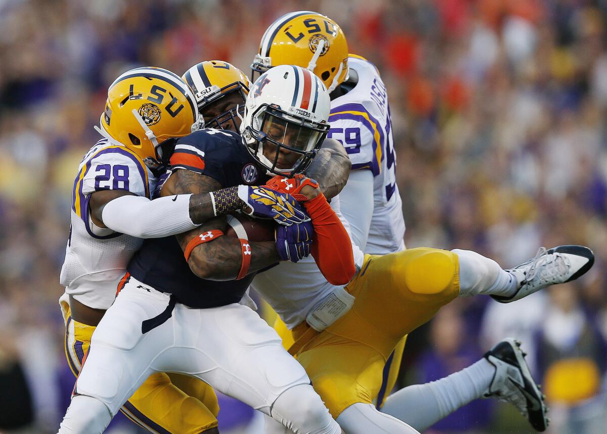 It takes three LSU defenders to take down Auburn quarterback Nick Marshall, who passed for 207 yards and two touchdowns and ran for 119 and two more scores on Saturday.