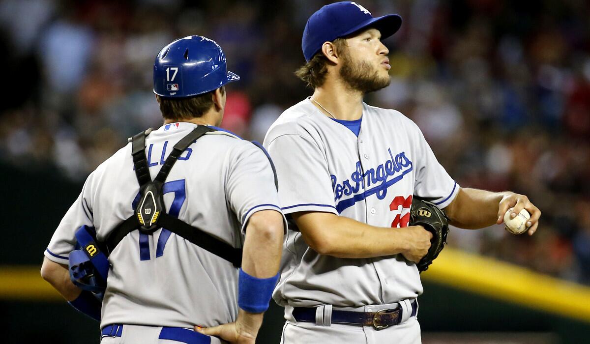 Dodgers pitcher Clayton Kershaw catches his breath ascatcher A.J. Ellis pays him a visit during a seven-run second inning for the Diamondbacks on Saturday evening in Phoenix.