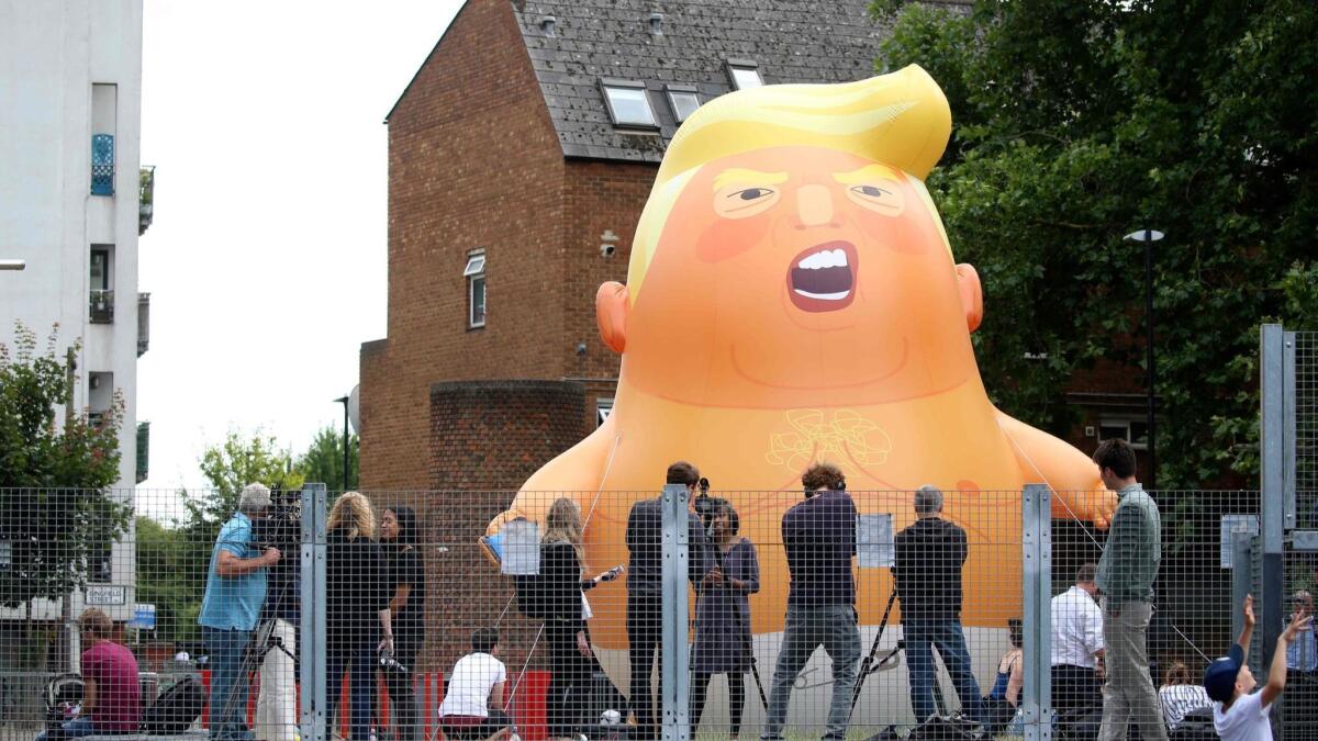 Activists in London inflate a giant balloon depicting U.S. President Trump as an orange baby on July 10, 2018, ahead of his visit.