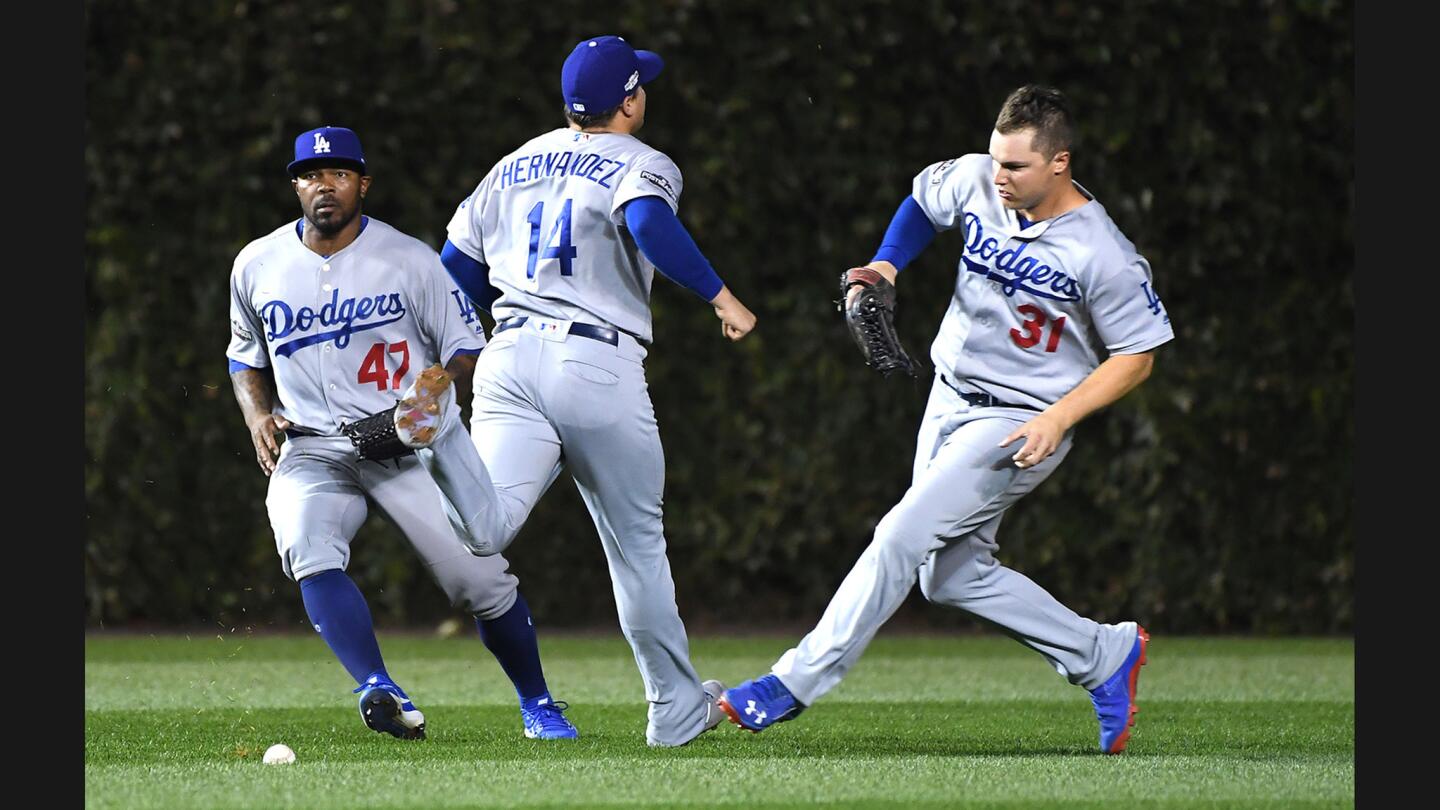 Dodgers teammates (from left) Howie Kendrick, Enrique Hernandez and Joc Pederson can't catch a pop fly in shallow left-center field by Cubs second baseman Javier Baez in the second inning of Game 1.