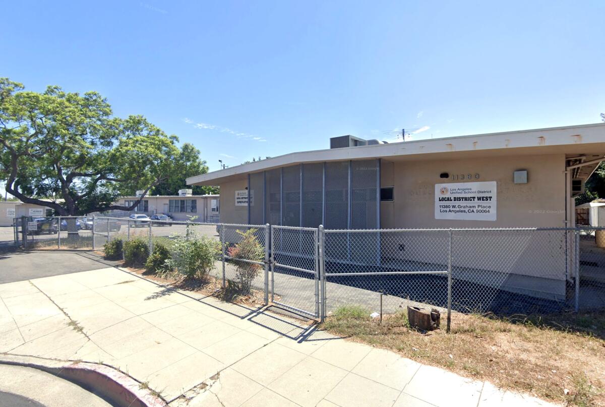 A low building with a fence in front of it.