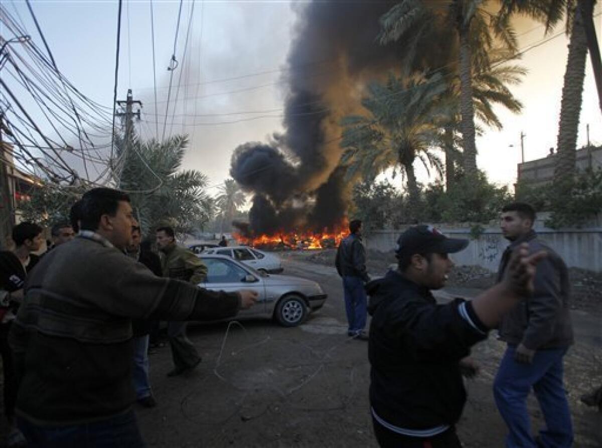 Iraqis react at the site of a car bomb attack in Baghdad, Iraq, Tuesday, Dec. 15, 2009. A series of car bombs ripped through downtown Baghdad near the heavily fortified Green Zone. (AP Photo/Hadi Mizban)