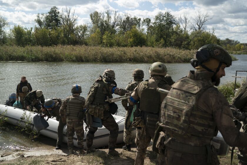 Soldados ucranianos del regimiento Dnipro-1 descargan un bote el domingo 25 de septiembre de 2022 en la localidad de Shchurove, Ucrania, recuperada de las fuerzas rusas. (AP Foto/Leo Correa)