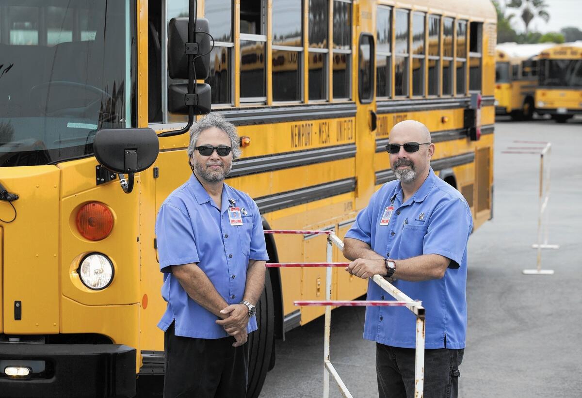 Norm Turner, left, transportation operations supervisor, and Victor Garza, a delegated behind the wheel trainer, with obstacle course props at the Transportation Department's bus yard in Costa Mesa on Thursday. Garza represented California in the 45th annual School Bus Driver International Safety Competition and took first place in the Transit category. Eight of Newport-Mesa's drivers participated in several bus driving and safety "Roadeo" events this past school year, taking home various trophies and awards.