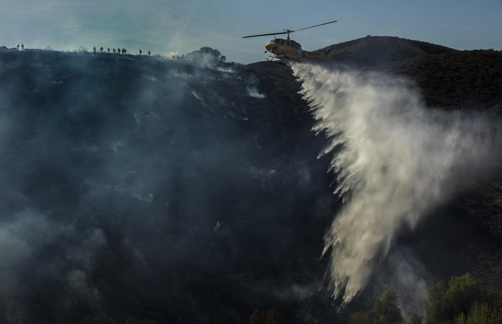 A pilot with the Ventura County Fire Department makes a water drop on the Country fire in Westlake Village.