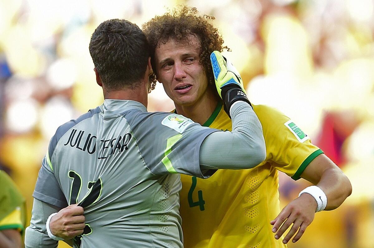 Brazil defender David Luiz cries as he hugs goalkeeper Julio Cesar after they won their match against Chile.