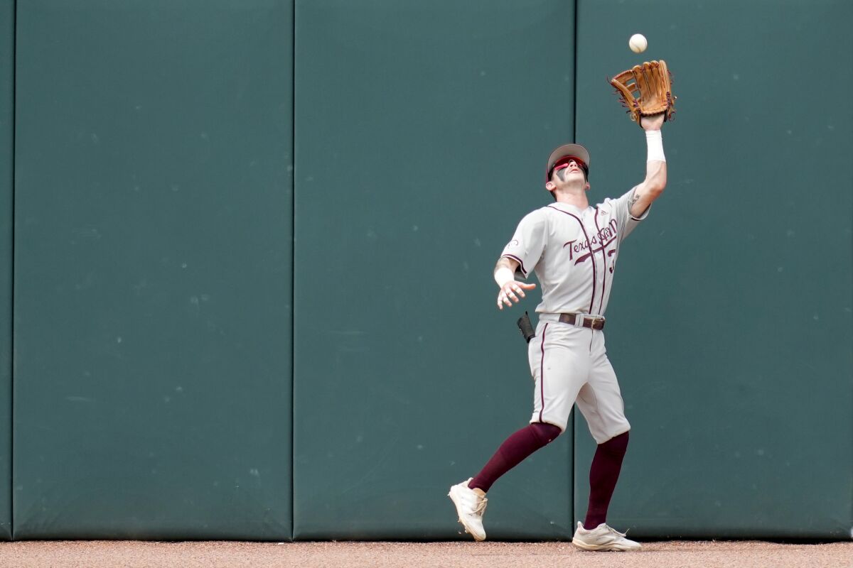 Texas A&M outfielder Jordan Thompson (31) catches a ball on the warning track for an out against Louisville during an NCAA college baseball super regional tournament game Saturday, June 11, 2022, in College Station, Texas. (AP Photo/Sam Craft)