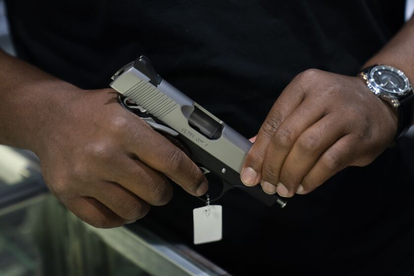 Sales associate Elsworth Andrews shows a handgun to a customer at Burbank Ammo & Guns in Burbank, Calif., Thursday, June 23, 2022. The Supreme Court has ruled that Americans have a right to carry firearms in public for self-defense, a major expansion of gun rights. The court struck down a New York gun law in a ruling expected to directly impact half a dozen other populous states. (AP Photo/Jae C. Hong)