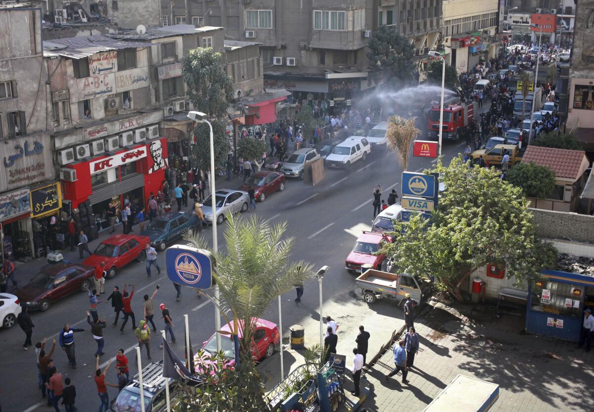 In downtown Cairo, police fire a water cannon to disperse a protest by dozens of activists commemorating the death of a protester a year earlier.