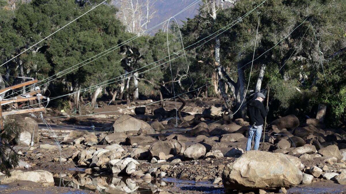 A man stands near downed power lines in Montecito on Jan. 10.