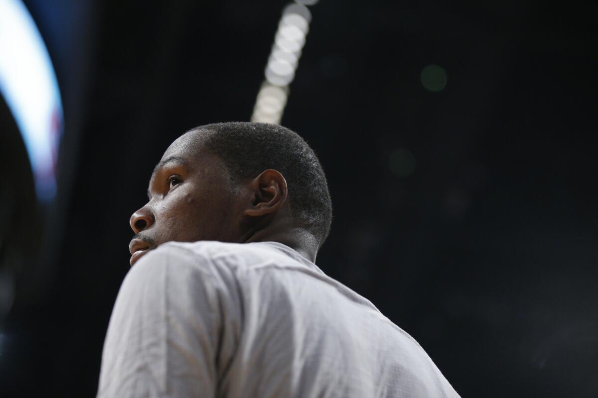 Thunder forward Kevin Durant looks away while on the bench during the second half of a game against the Lakers.
