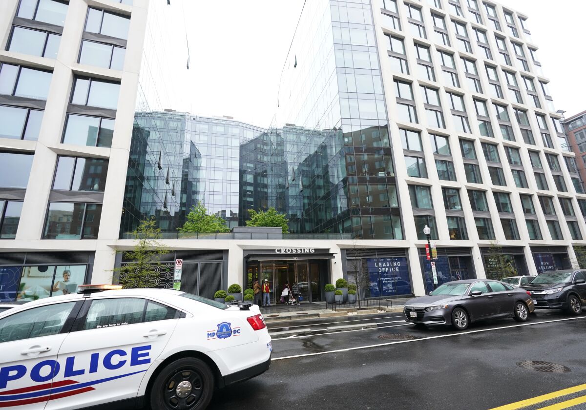 A Metropolitan Police patrol car is parked in front of a a luxury apartment building in Southeast Washington, Thursday, April 7, 2022. Federal prosecutors on Wednesday charged two men they say were posing as federal agents, giving free apartments and other gifts to U.S. Secret Service agents, including one who worked on the first lady's security detail. (AP Photo/Manuel Balce Ceneta)