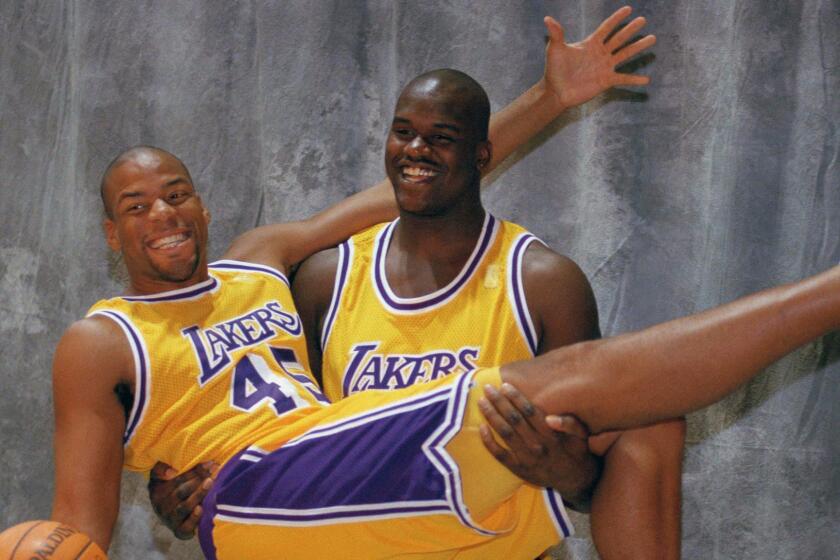 Los Angeles Lakers Shaquille O'Neal holds up fellow center Sean Rooks as they pose for a picture at Lakers Media Day at the Forum in Inglewood in 1996.