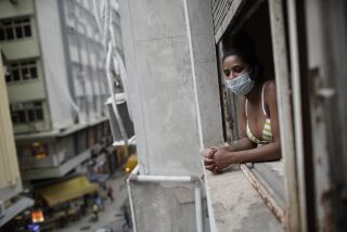 Actress Kelly Regina da Silva looks out from the window of her room in a building occupied by squatters in Rio de Janeiro, Brazil, Tuesday, March 16, 2021. Before the coronavirus pandemic hit da Silva had made it out of her working-class favela and landed a leading role in a play showing right across from Ipanema beach. (AP Photo/Silvia Izquierdo)