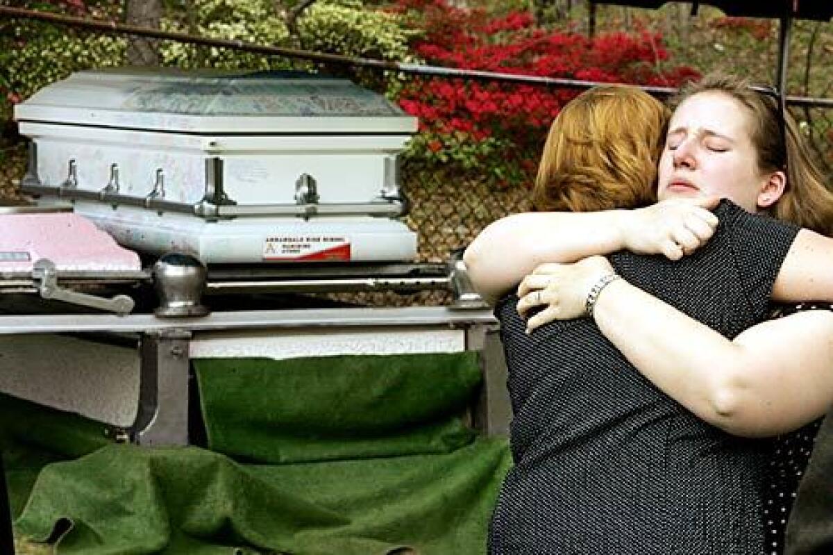Mourners console each other by the casket of Virginia Tech freshman Mary Karen Read, 19, who was killed in last week's Virginia Tech shooting, during her funeral at Pleasant Valley Memorial Park in Annandale, Va.