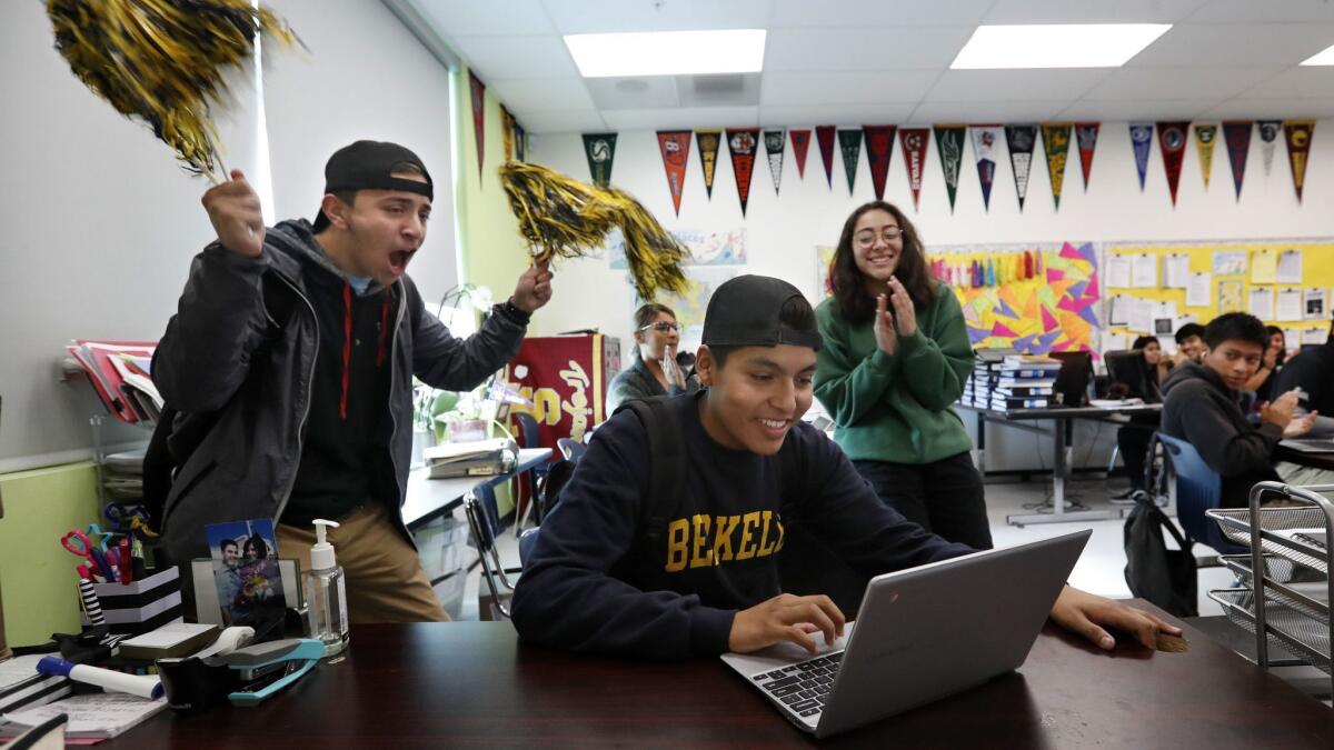 Bryan Hernandez, 17, center, is cheered on by Jason Gutierrez, 17, left, and Melissa Solis, 17, as he submits an application to Louisiana State University at the college center at Tajima High School.