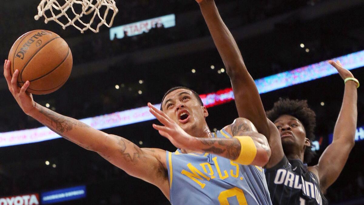 Lakers' Kyle Kuzma shoots while being guarded by Orlando's Jonathan Isaac on March 7 at Staples Center.