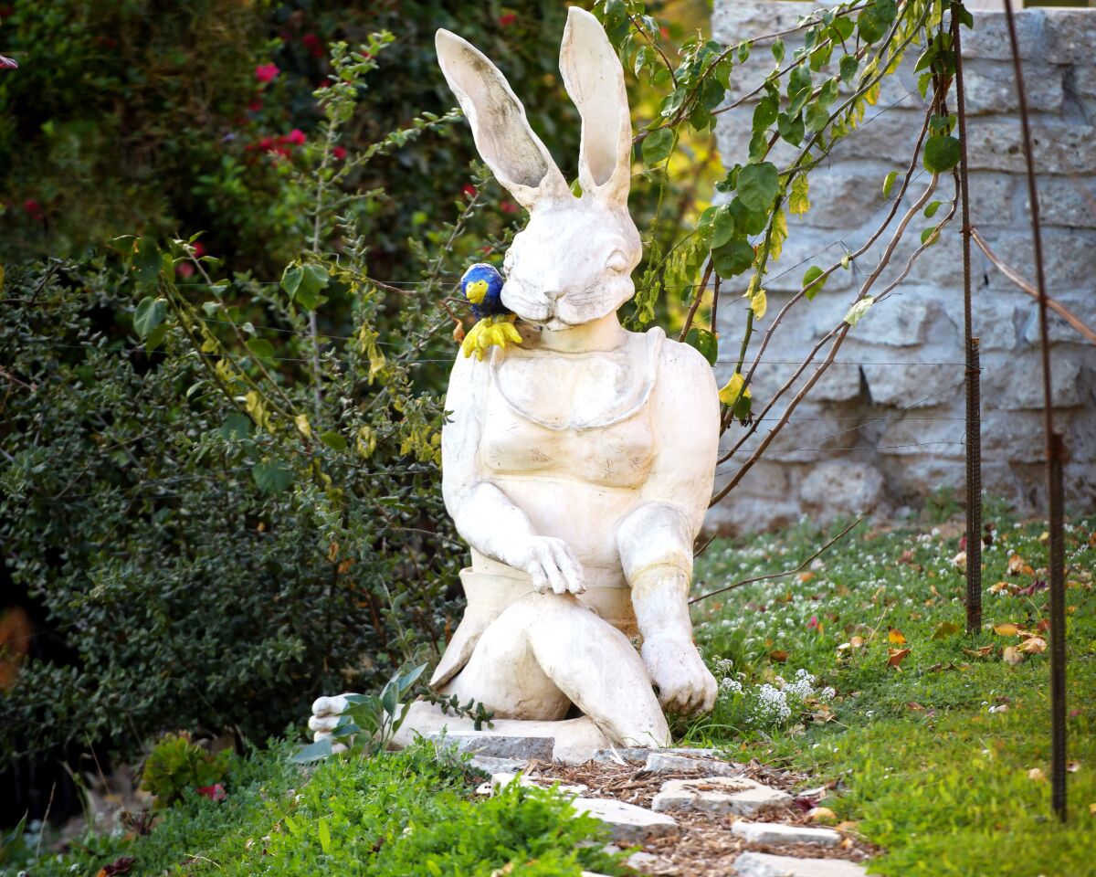 A ceramic sculpture of a rabbit in a garden