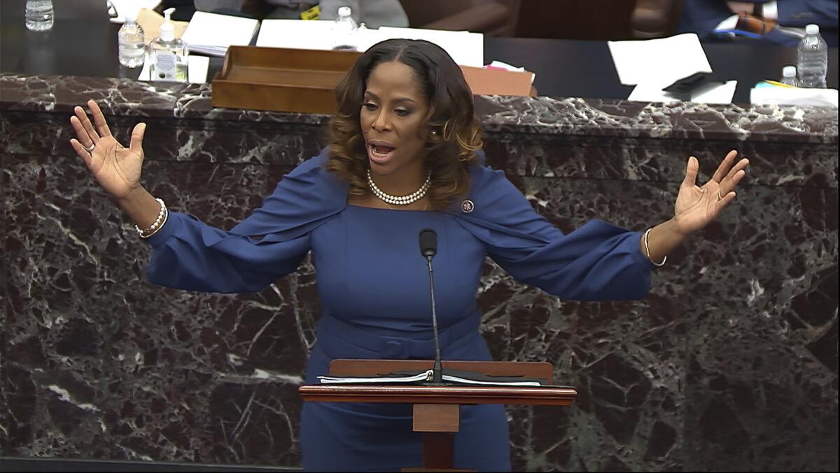 House manager Stacey Plaskett speaks and gestures at a Senate lectern