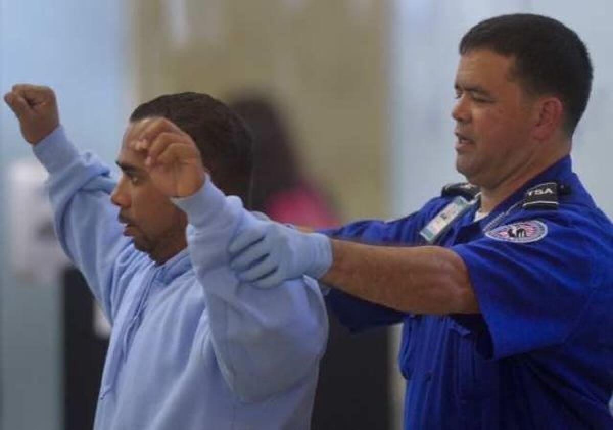 A travelers gets a pat-down search at John Wayne Airport.