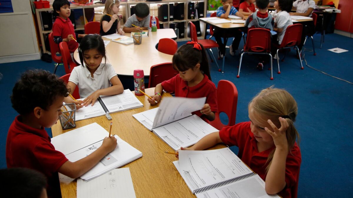 Children fill in workbooks in a classroom.