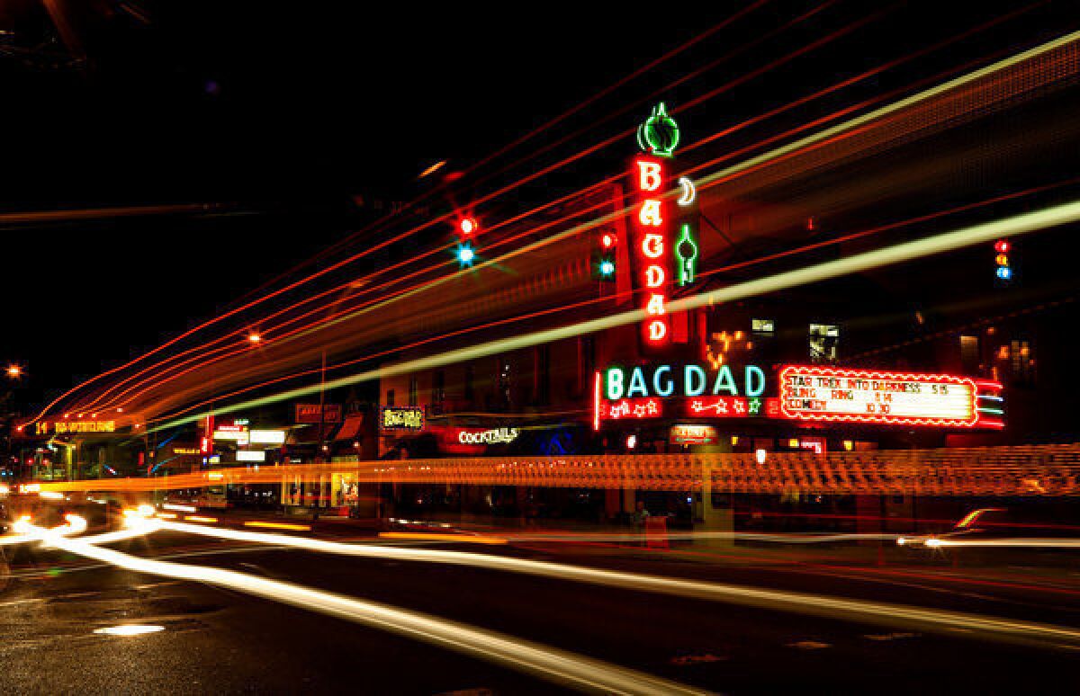 Lights from cars and buses streaking past the Bagdad add to the allure of the neon-bedazzled theater in Portland, Ore.