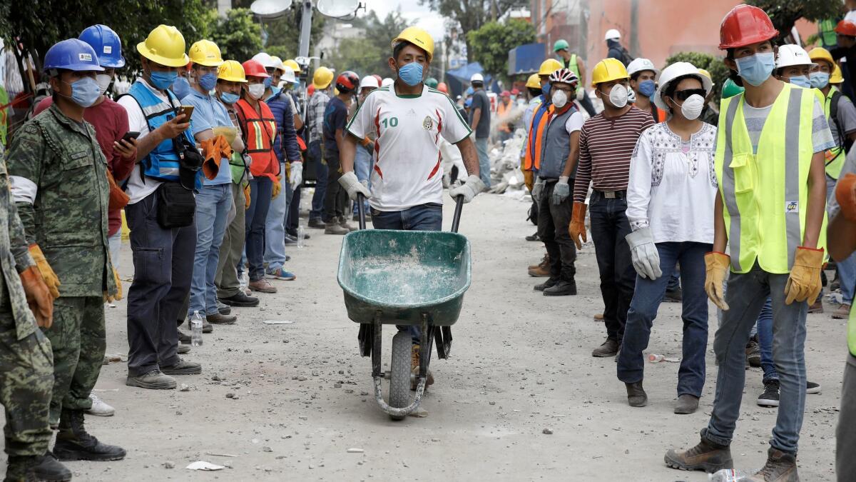 Volunteers work to remove rubble from the Neto supermarket where people were found dead in Mexico City's Xochimilco area.