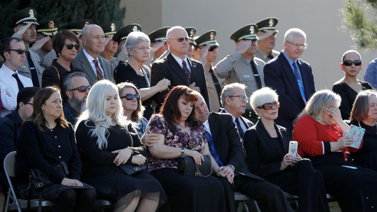 Steven Belanger's family and friends mourn as L.A. County sheriff's officials salute the flag at his funeral.
