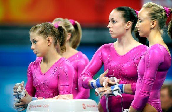 U.S. gymnasts, from left, Shawn Johnson. Chellsie Memmel and Nastia Liukin, chalk up their hands before practicing on the uneven parallel bars in preparation for the 2008 Beijing Olympics.