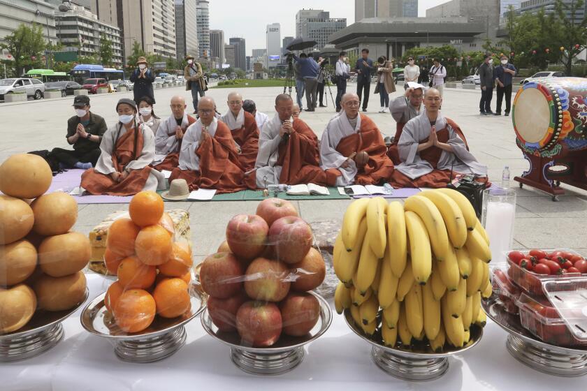Buddhists monks in Seoul pray on Thursday during a service for victims who died after being infected with the coronavirus.