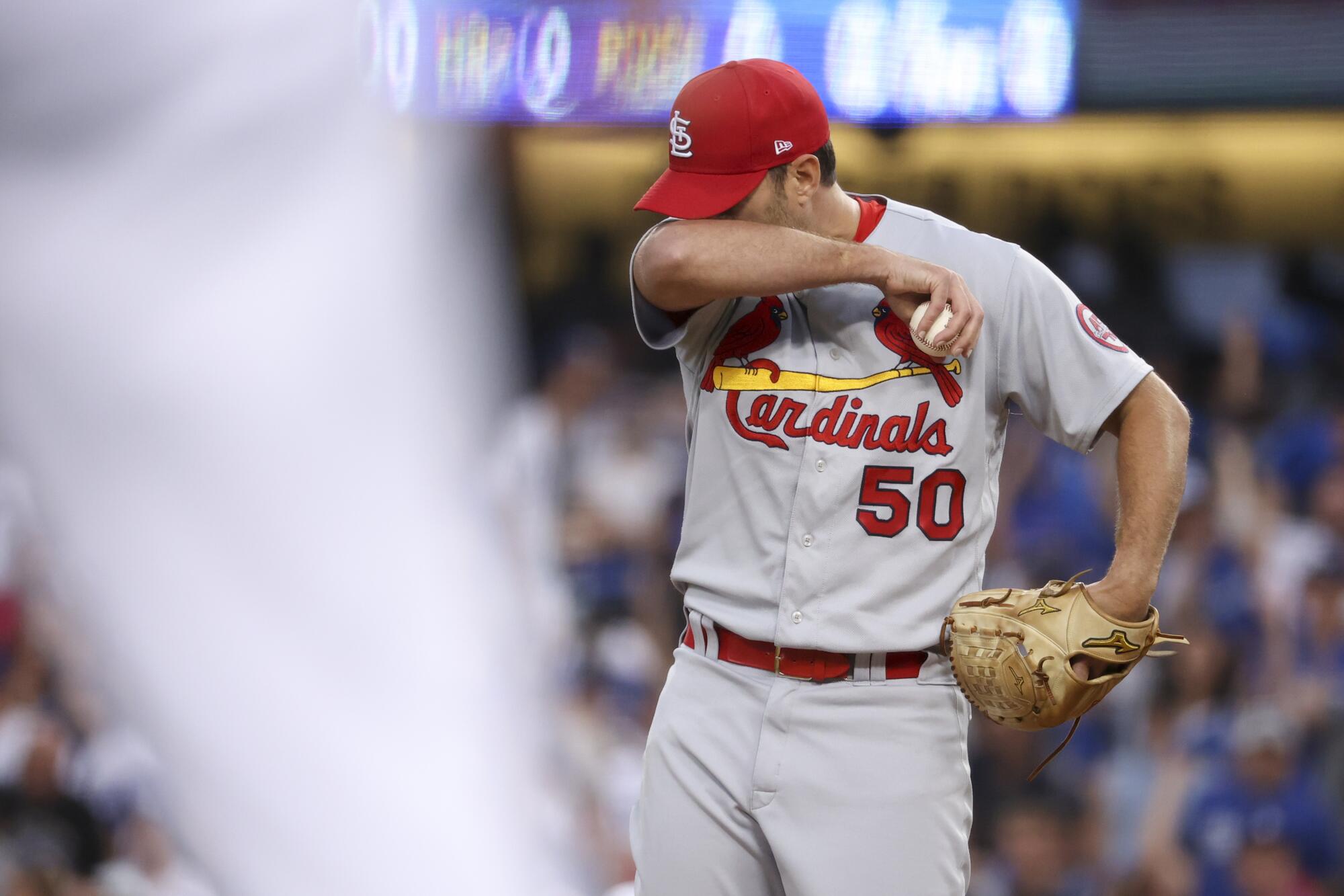 St. Louis Cardinals starting pitcher Adam Wainwright wipes his face 