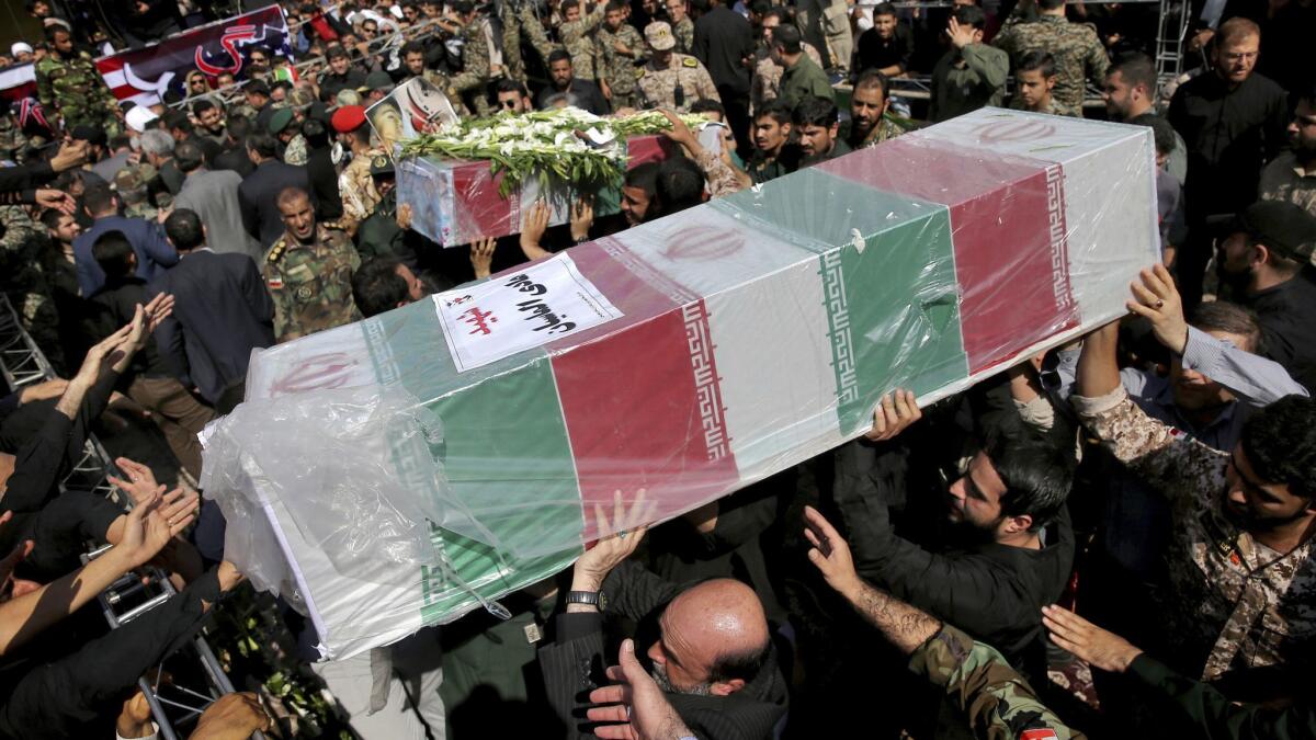 Mourners carry flag-draped caskets during a mass funeral for victims of Saturday's terrorist attack on a military parade in the southwestern city of Ahvaz, Iran, on Sept. 24, 2018.