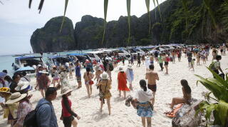 Tourists enjoy the beach on Maya Bay, Phi Phi Leh island in Krabi province, Thailand