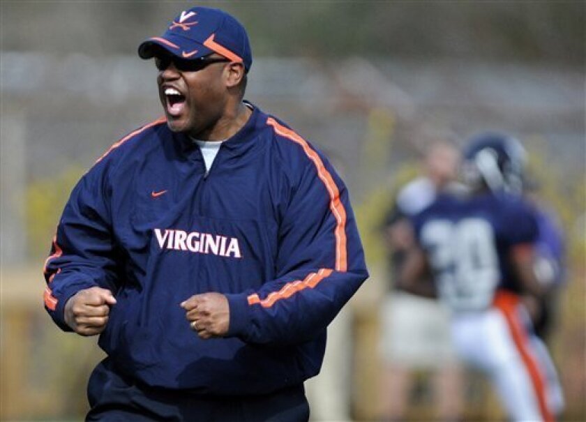 FILE - In this file photo taken March 24, 2010, Virginia head coach Mike London cheers during spring NCAA college football practice in Charlottesville, Va. A year ago Latrell Scott was coaching wide receivers at Virginia and London was the head coach at Richmond. On Saturday, Sept. 4, 2010, London will make his debut as Virginia's head coach against his former team, now led by Scott. (AP Photo/The Daily Progress, Megan Lovett, File)