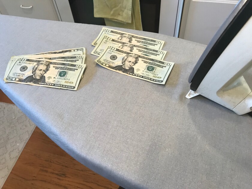 Twenty dollar bills on an ironing board
