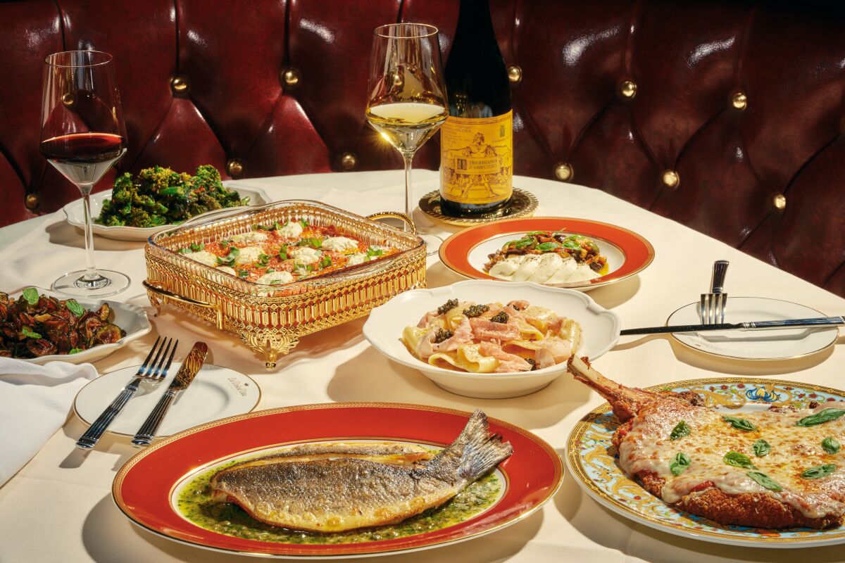Plates of pastas, veal Parmesan, fish, salad and glasses of wine on a table at La Dolce Vita in Beverly Hills.