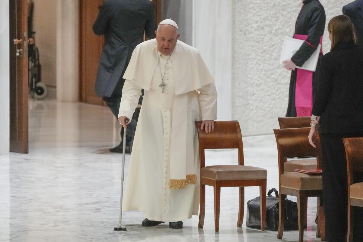 Pope Francis walks with a cane.