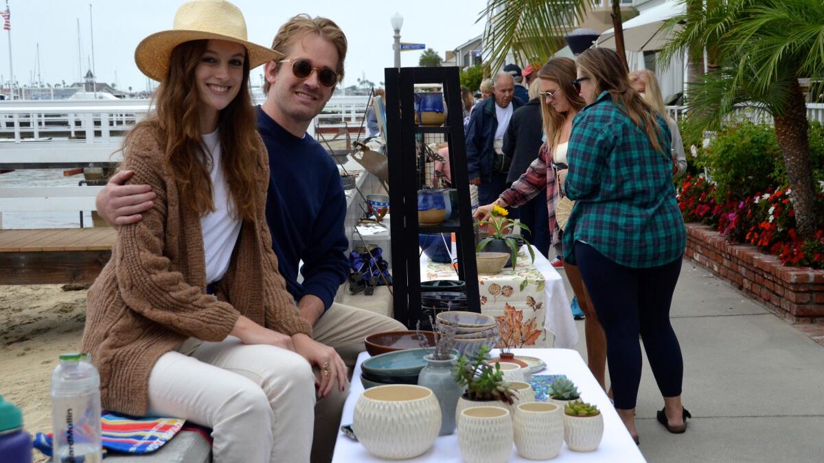 First-time exhibitor Ian Stuart and girlfriend Emily Floyd sit on seawall during the Balboa Island ArtWalk on Sunday.