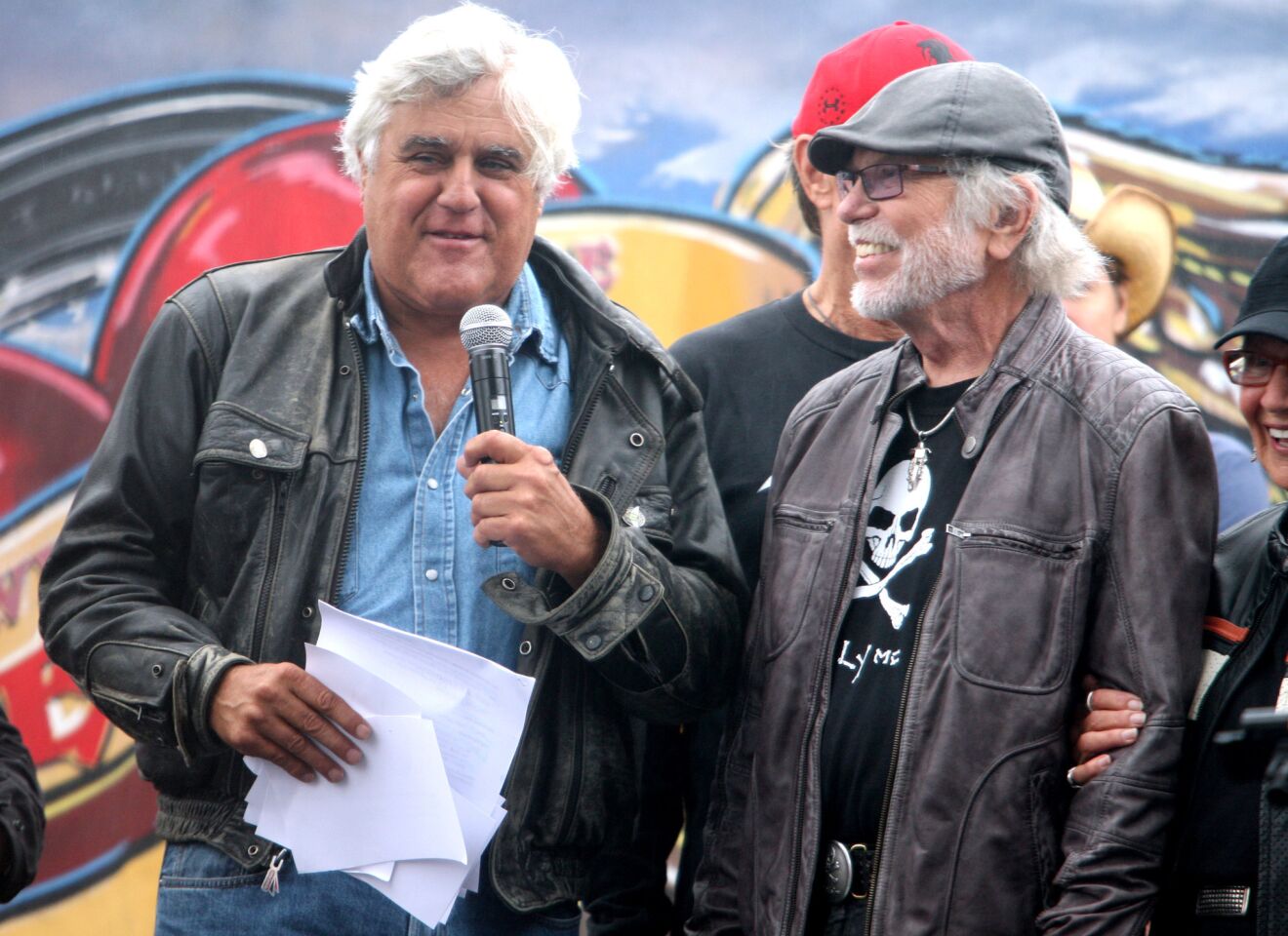 Thirty-second annual Love Ride host Jay Leno, left, introduces legendary motorcycle designer Willie G. Davidson prior to the start of the event at Harley-Davidson Motorcycles in Glendale on Sunday, October 18, 2015. This will be the last fundraising Love Ride.