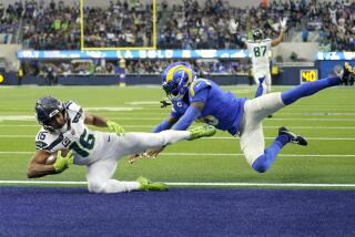 Seattle Seahawks wide receiver Tyler Lockett catches a pass ahead of Los Angeles Rams defensive back Jalen Ramsey.